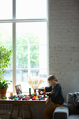 Image showing Girl playing with constructor at home, watching teacher\'s tutorial on laptop. Digitalization, remote education