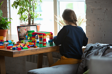 Image showing Girl playing with constructor at home, watching teacher\'s tutorial on laptop. Digitalization, remote education