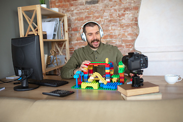 Image showing Man giving online lesson with constructor at home. Recording teacher\'s tutorial on camera for kids. Digitalization, remote education