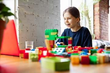 Image showing Girl playing with constructor at home, watching teacher\'s tutorial on laptop. Digitalization, remote education