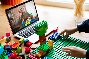 Image showing Girl playing with constructor at home, watching teacher\'s tutorial on laptop. Digitalization, remote education