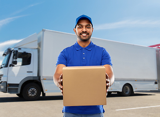 Image showing happy indian delivery man with parcel box in blue