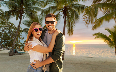 Image showing happy friends walking along summer beach