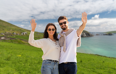 Image showing happy couple waving hands in ireland