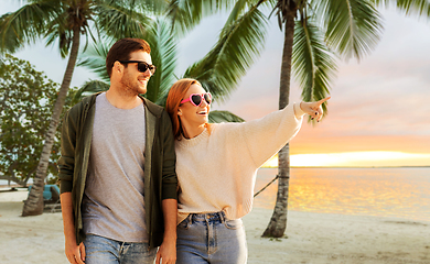 Image showing happy couple walking along summer beach