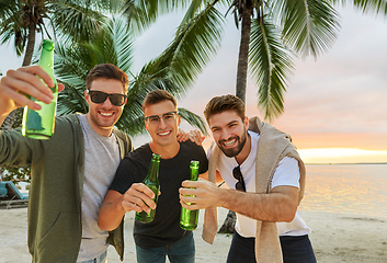 Image showing young men toasting non alcoholic beer on beach