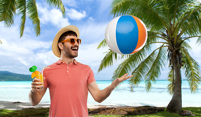 Image showing happy man with orange juice and beach ball