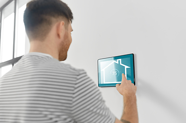 Image showing man looking at tablet computer at smart home