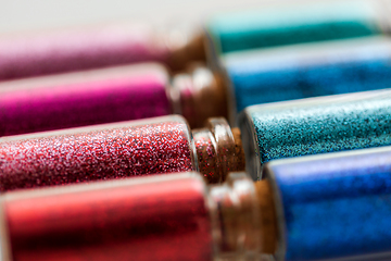 Image showing set of different glitters in small glass bottles