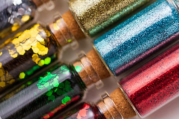 Image showing set of different glitters in small glass bottles