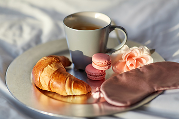 Image showing croissant, coffee and eye sleeping mask in bed