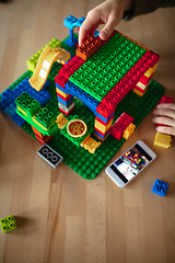 Image showing Close up of male hands playing with colorful plastic constructor on wooden background