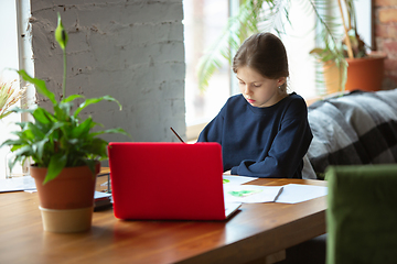 Image showing Girl drawing with paints and pencils at home, watching teacher\'s tutorial on laptop. Digitalization, remote education