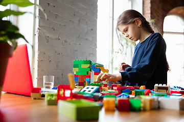 Image showing Girl playing with constructor at home, watching teacher\'s tutorial on laptop. Digitalization, remote education