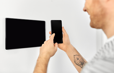 Image showing man with smartphone and tablet pc at smart home