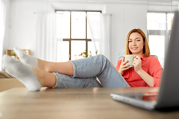 Image showing woman with laptop drinking coffee at home office