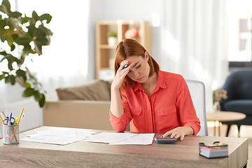 Image showing woman with calculator and papers working at home