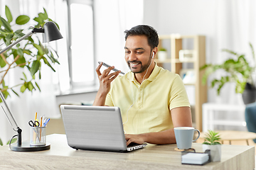 Image showing man recording voice on smartphone at home office