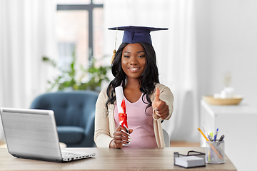 Image showing graduate student with laptop and diploma at home