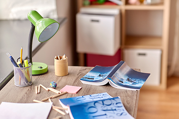 Image showing school supplies scattered on table at home