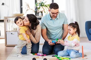 Image showing happy family palying with wooden toys at home