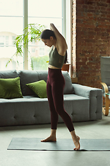 Image showing Sporty young woman practicing yoga at home