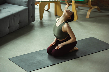 Image showing Sporty young woman practicing yoga at home