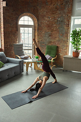 Image showing Sporty young woman practicing yoga at home