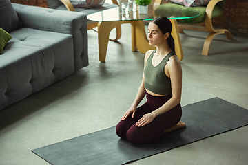 Image showing Sporty young woman practicing yoga at home