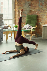 Image showing Sporty young woman practicing yoga at home