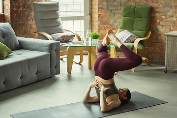 Image showing Sporty young woman practicing yoga at home