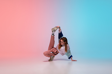 Image showing Girl dancing hip-hop in stylish clothes on gradient background at dance hall in neon light.