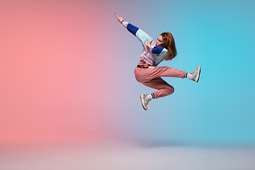 Image showing Girl dancing hip-hop in stylish clothes on gradient background at dance hall in neon light.