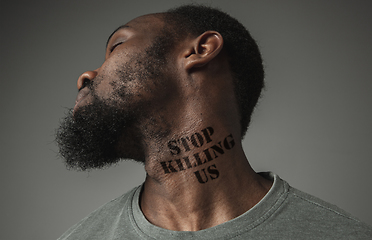 Image showing Close up portrait of a black man tired of racial discrimination has tattooed slogan on his neck