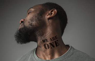 Image showing Close up portrait of a black man tired of racial discrimination has tattooed slogan on his neck