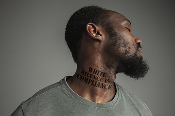 Image showing Close up portrait of a black man tired of racial discrimination has tattooed slogan on his neck