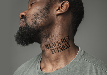 Image showing Close up portrait of a black man tired of racial discrimination has tattooed slogan on his neck