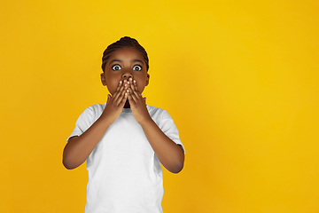 Image showing Little african-american girl\'s portrait isolated on yellow studio background