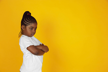 Image showing Little african-american girl\'s portrait isolated on yellow studio background