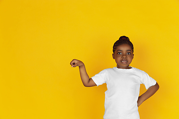 Image showing Little african-american girl\'s portrait isolated on yellow studio background