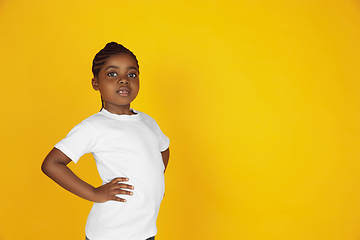 Image showing Little african-american girl\'s portrait isolated on yellow studio background