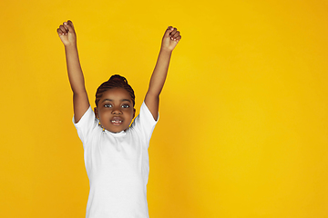 Image showing Little african-american girl\'s portrait isolated on yellow studio background