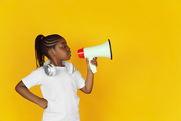 Image showing Little african-american girl\'s portrait isolated on yellow studio background