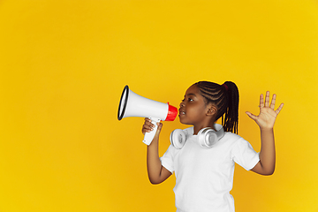 Image showing Little african-american girl\'s portrait isolated on yellow studio background