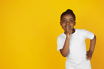 Image showing Little african-american girl\'s portrait isolated on yellow studio background