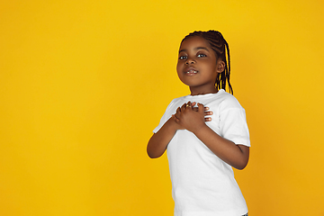 Image showing Little african-american girl\'s portrait isolated on yellow studio background