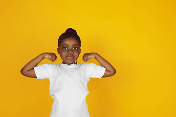 Image showing Little african-american girl\'s portrait isolated on yellow studio background