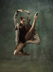 Image showing Young graceful tender ballerina on dark studio background