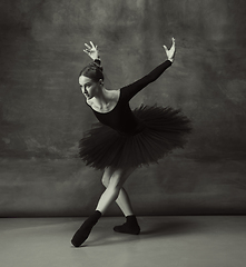 Image showing Young graceful tender ballerina on dark studio background