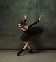 Image showing Young graceful tender ballerina on dark studio background